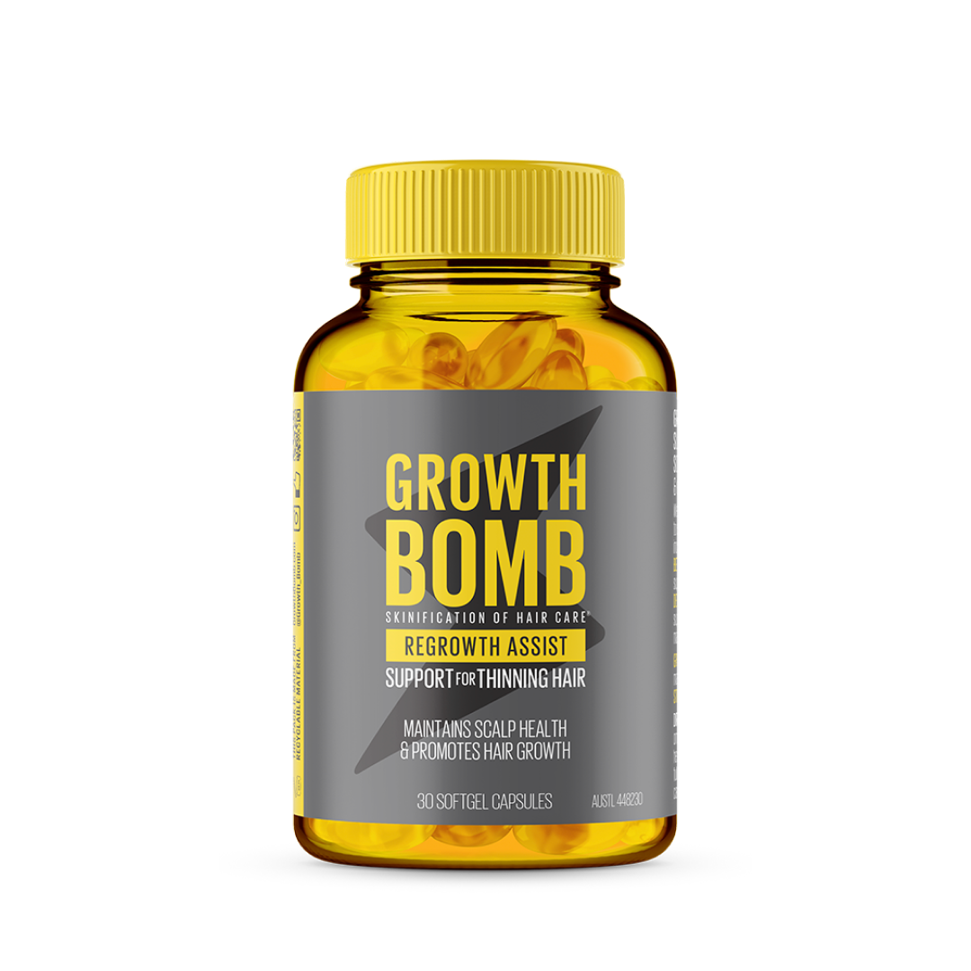 A bottle of Growth Bomb USs Regrowth Assist Support for Thinning Hair Supplement with a yellow label promotes hair growth and scalp health. Maintain thick hair with 30 nourishing softgel capsules designed to support thinning hair.