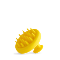 The Growth Bomb Silicone Scalp Brush is yellow with a handle, featuring soft spikes for hair and scalp exfoliation, shown on a white background.