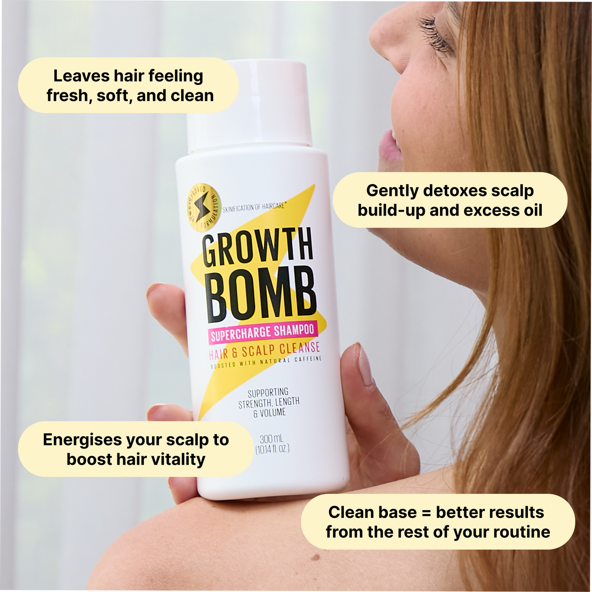 Growth Bomb supercharge shampoo bottle with white cap held near a smiling face