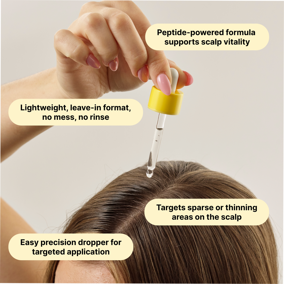 Dropper dispensing hair serum onto scalp with yellow-capped applicator
