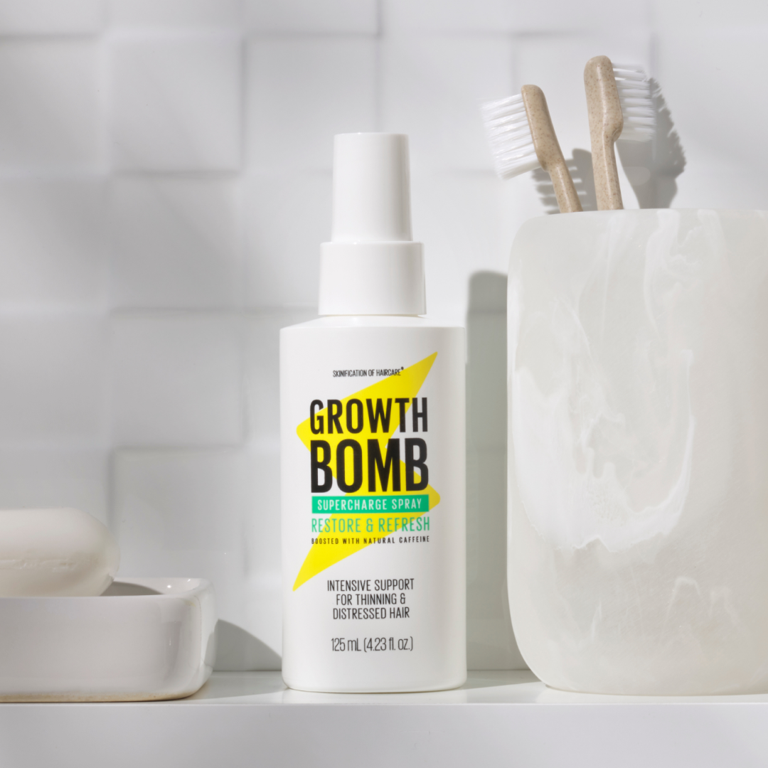 The Rescue, Restore & Hydrate Bundle by Growth Bomb US sits on a bathroom counter, accompanied by two wooden toothbrushes in a marble holder. The white tiles enhance the clean and simple aesthetic, perfectly showcasing your ultimate rescue remedy.