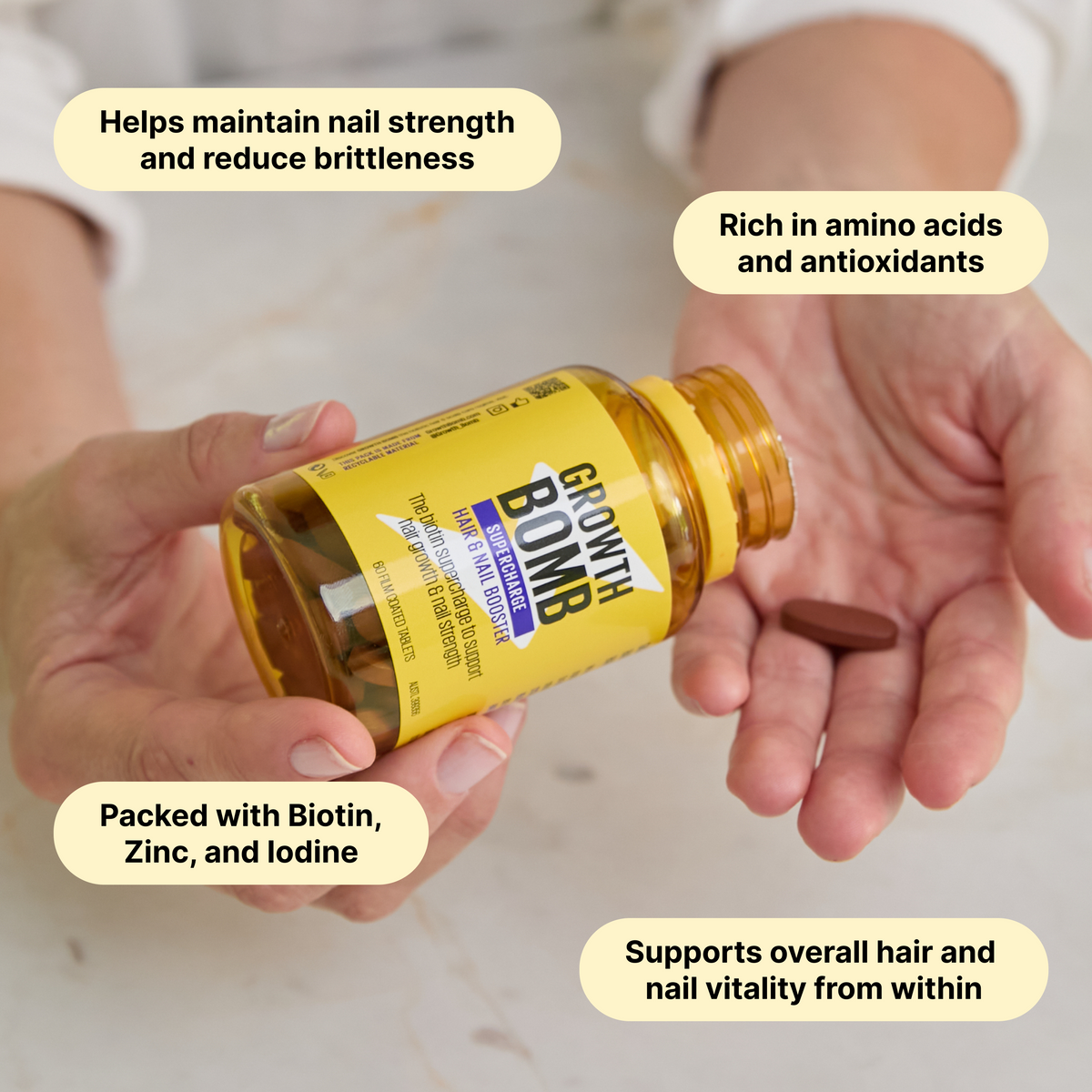 Hair and nail booster bottle held in hand with gold cap and yellow label