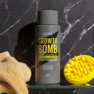 Shampoo and conditioner bottle with yellow scalp massager brush on countertop