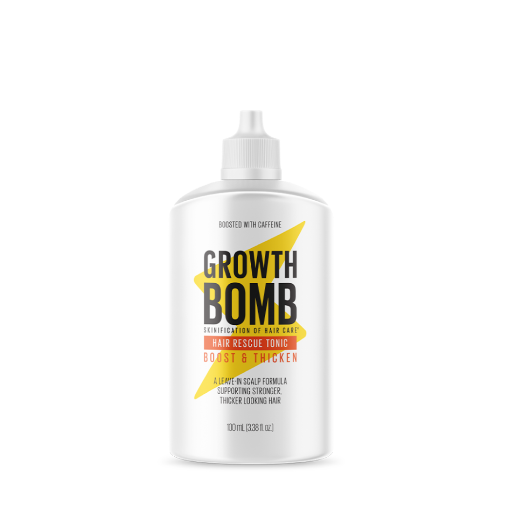 The image shows a white bottle of the Hair Rescue Tonic from Growth Bomb, featuring bold black and yellow text on its label. The tonic has a caffeine-boosted formula for improved scalp condition and stronger hair, with the bottle containing 100 mL (3.38 fl oz).